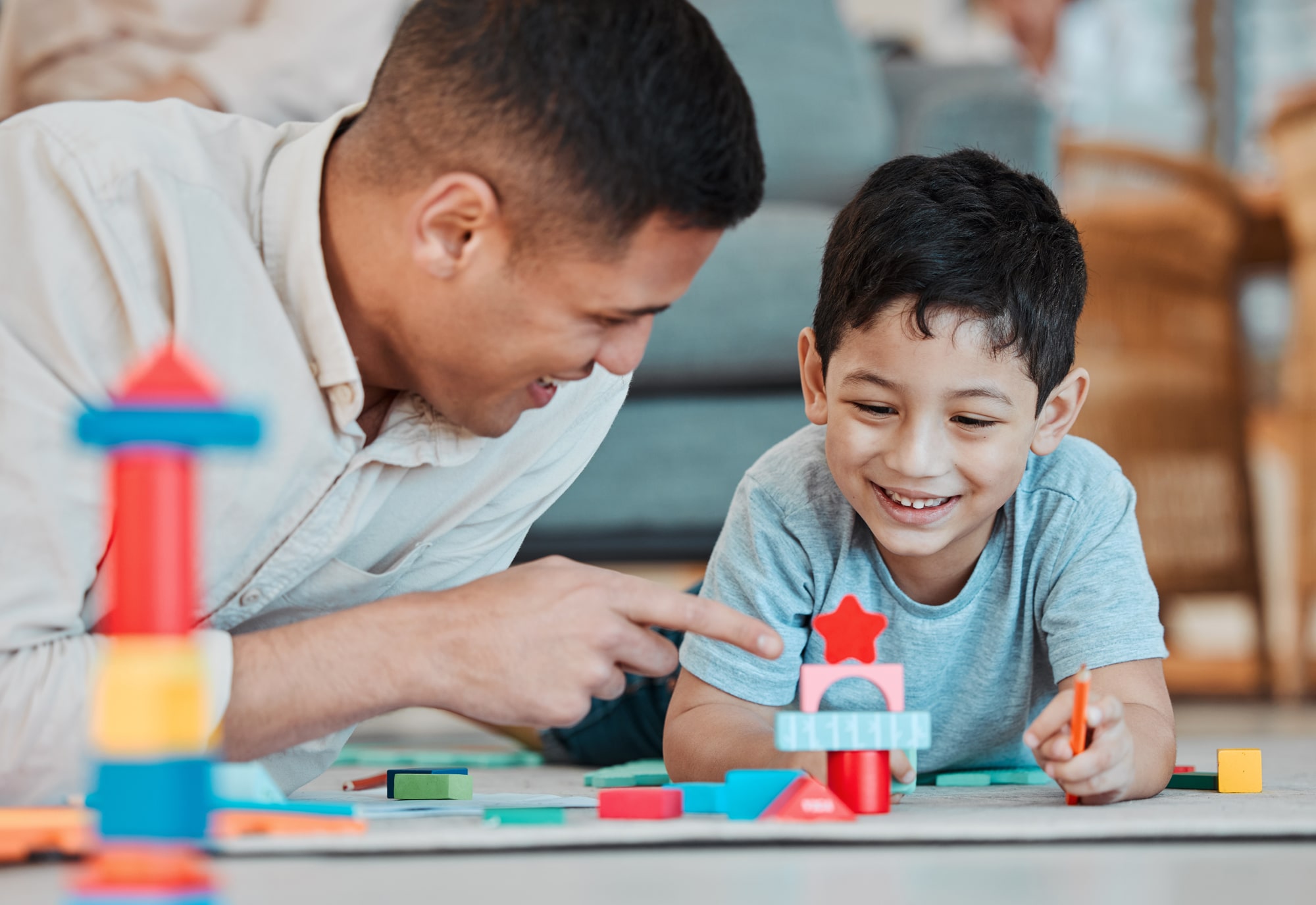 Dad and child playing with toys on the living room floor