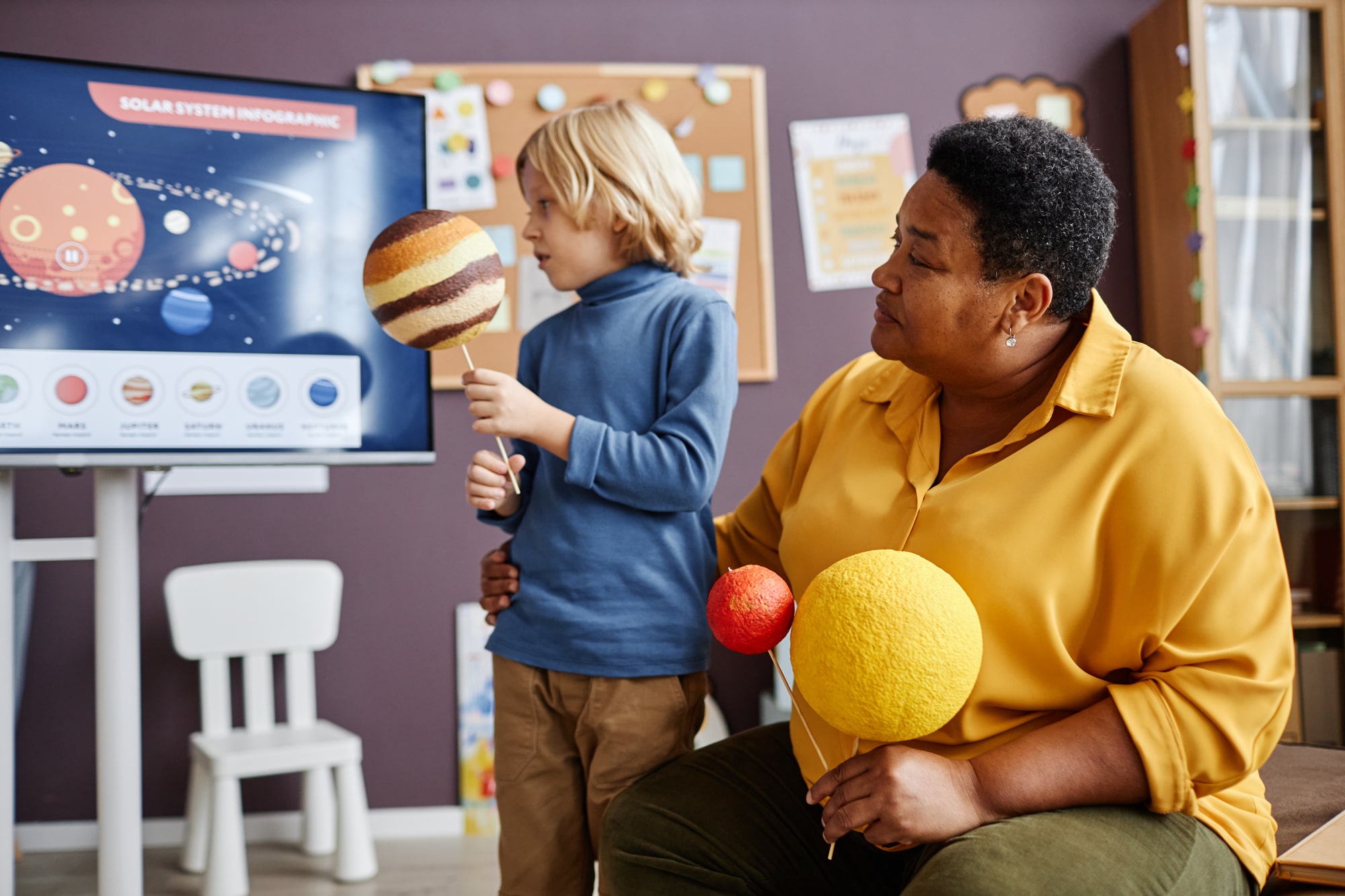 Nursery school teacher working with a young student