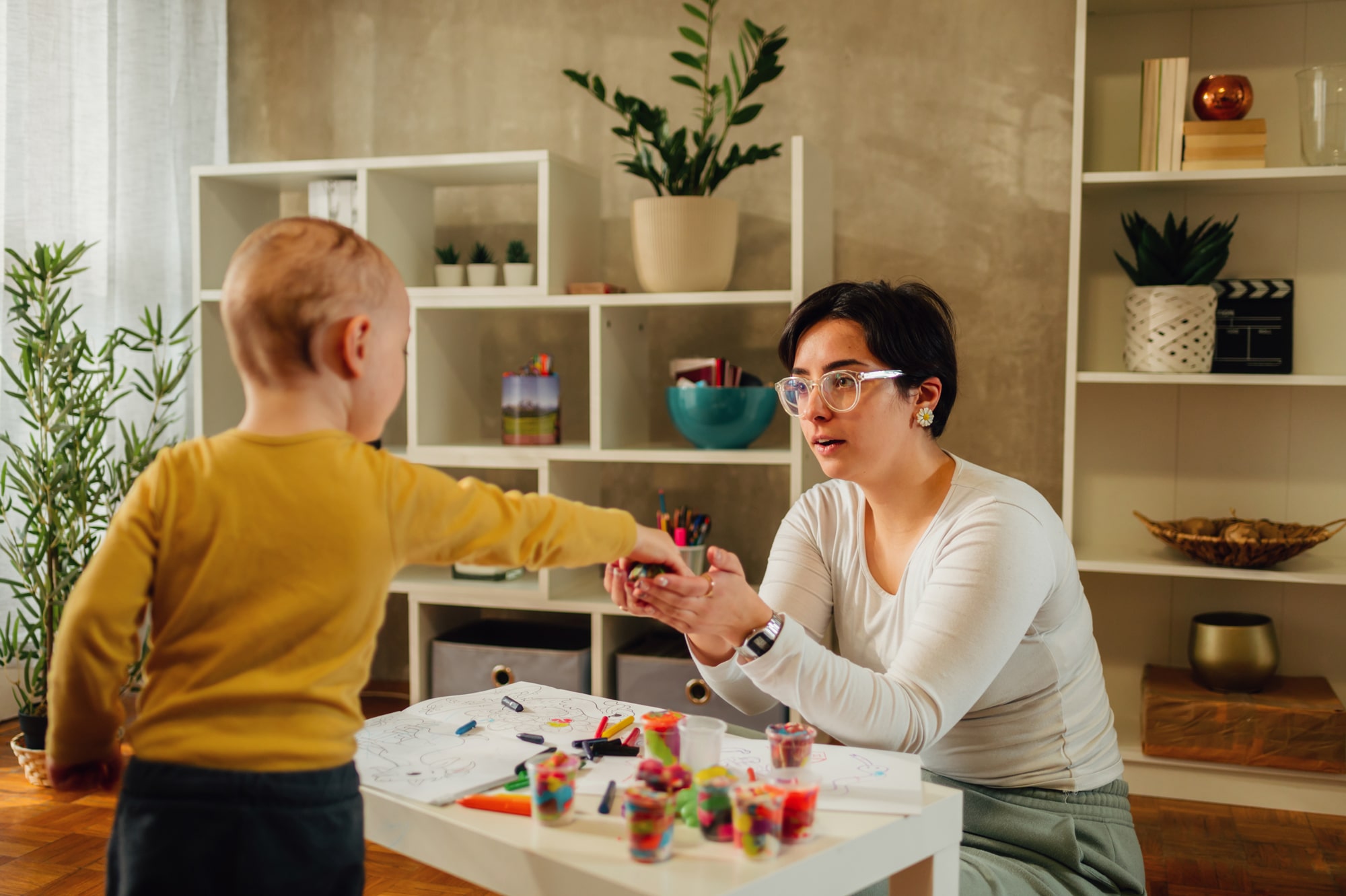 Mother and son drawing with crayons together at home